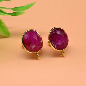 Puede incluir: Un par de pendientes de oro con detalles de piedras preciosas rosas. Los pendientes tienen un diseño sencillo y son perfectos para el uso diario.