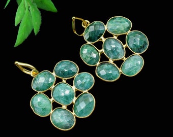 May include: A pair of gold earrings with a cluster of green gemstone drops. Each earring features seven oval-shaped gemstones.