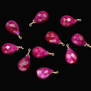 Può includere: Dieci perline di pietra preziosa rosa sfaccettate a forma di goccia con anelli a salto dorati.