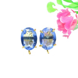 May include: A pair of oval-shaped earrings with blue gemstone accents and gold settings.