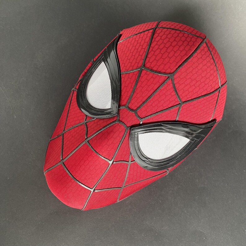 May include: A red Spider-Man mask with a web pattern and black trim around the eyes. The eye openings are white mesh. The mask is a full head covering.