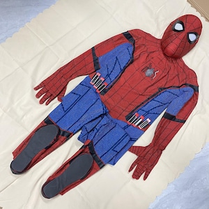 May include: A red and blue Spider-Man costume, including a full-face mask, gloves, and a jumpsuit. The costume features a web pattern on the red areas and blue panels on the torso and legs. The mask has white eye lenses.