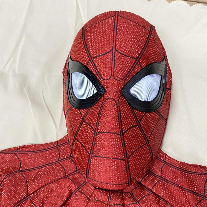 May include: A red and black Spider-Man mask with white eye lenses and a webbed pattern. The mask is made of a textured material and is designed to cover the entire head. The eye lenses are outlined in black.