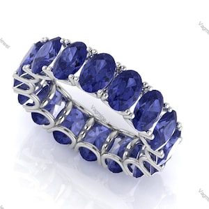 Peut inclure: Une bague en argent avec une rangée de pierres bleues ovales. La bague est sertie de 10 pierres au total.
