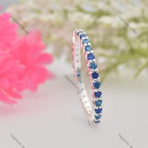 Könnte beinhalten: Ein Silberring mit einer Reihe blauer Saphire in Pavé-Fassung.