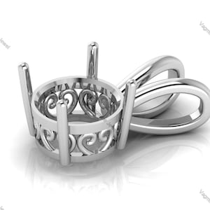 May include: A silver pendant setting with a delicate, ornate design featuring a heart motif. The setting is designed to hold a round gemstone.