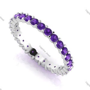 Może przedstawiać: Srebrny pierścionek z paskiem z rzędem małych, okrągłych, fioletowych ametystów.