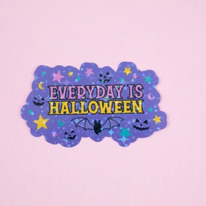 Puede incluir: Pegatina morada con un dise&ntilde;o brillante que presenta estrellas, lunas, murci&eacute;lagos y calabazas. El texto dice "EVERYDAY IS HALLOWEEN" en letras amarillas y rosas.