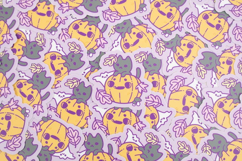 May include: A collection of stickers featuring cute cartoon pumpkins with black cats. The stickers are on a purple background with a white outline. The pumpkins are orange and yellow with black eyes and a smiling mouth. The cats are black with white eyes and a pink nose.