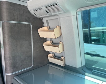 May include: Three wooden shelves mounted on a wall inside a vehicle. The shelves are made of light brown wood and have a simple design.
