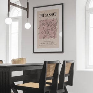 Puede incluir: Un p&oacute;ster enmarcado en negro con fondo rosa y un dibujo de l&iacute;nea negra de figuras bailando. El p&oacute;ster dice "PICASSO" y "MUS&Eacute;E D'ORSAY".
