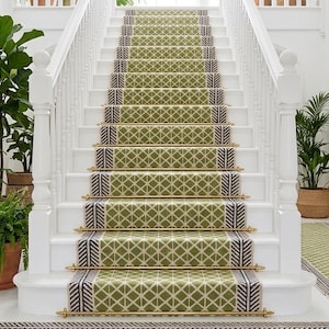 May include: A bright, airy entryway with a white staircase and a green patterned runner. Potted plants and macrame wall hangings add to the decor. A chandelier hangs from the ceiling, illuminating the space.