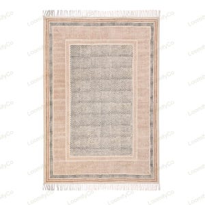 May include: A cream-colored rug with a geometric pattern in black and gray. The rug has a pink and brown border with a fringe on all sides.