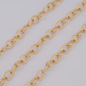Op de afbeelding: Drie strengen gouden ketting met ovale schakels.