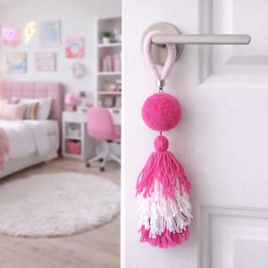 Big pink pom pom door knob hanger with long layered tassel. Small yarn wall hanging. Teenage girl bedroom decor ideas. Mini fiber wall art.