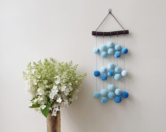 Small blue and white pom pom wall hanging. Vertical, narrow pompom wall art for boy nursery. Cloud theme nursery mobile. Baby shower gift.