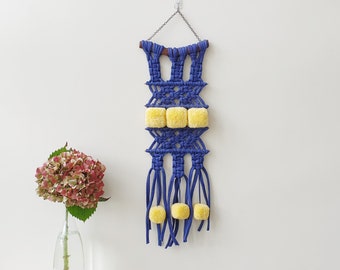 Small narrow cobalt blue macrame wall hanging with yellow pompoms. Narrow pom pom vertical wall art. Handmade modern yarn wall tapestry.