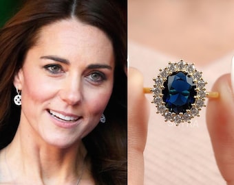 Könnte beinhalten: Ein goldener Ring mit einem großen, oval geschliffenen, tiefblauen Mittelstein, der von einem Kranz aus kleinen, klaren, rund geschliffenen Steinen umgeben ist. Das Band ist dünn und aus Gold, mit einem klassischen Design.