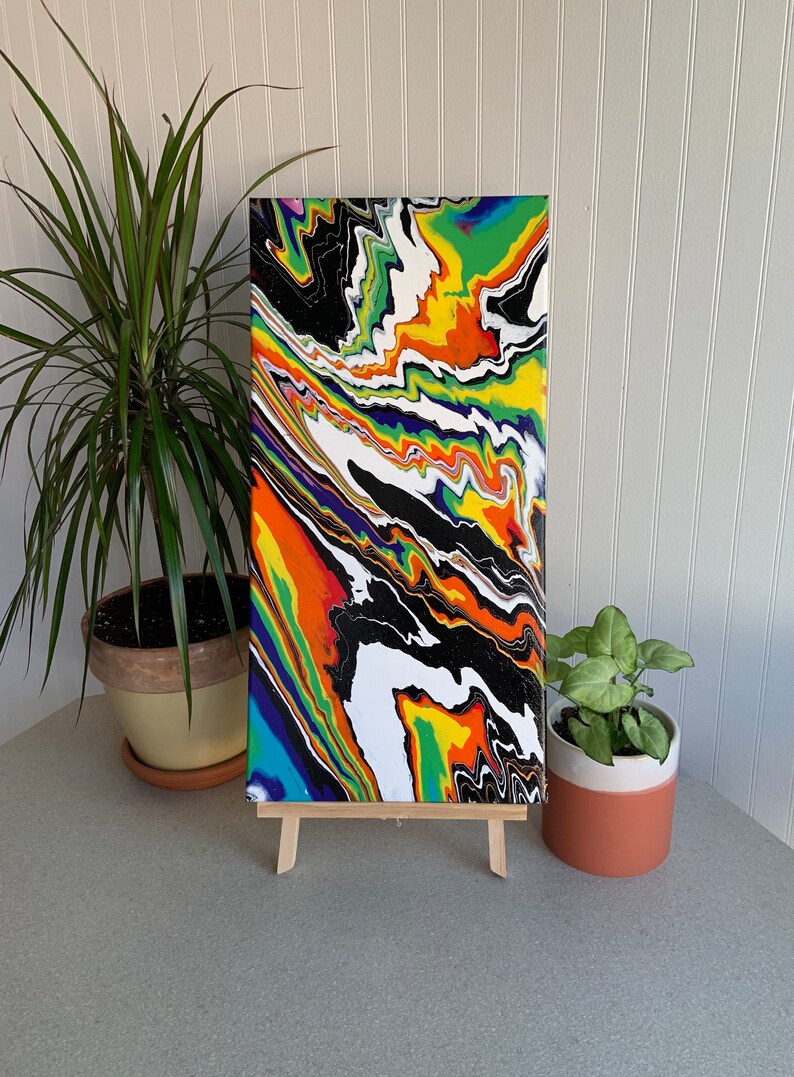 May include: Abstract painting on canvas with a colorful, swirling design in shades of black, white, green, yellow, orange, purple, and blue.