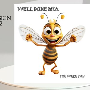 Pu&ograve; includere: Un biglietto di auguri con un'illustrazione di un'ape dei cartoni animati. L'ape &egrave; gialla e nera con le braccia tese e un volto sorridente. Il testo sul biglietto recita "WELL DONE MIA" e "YOU WERE FAB". Il biglietto &egrave; etichettato "DESIGN 2".