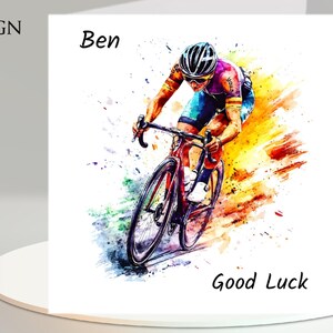 May include: A watercolor-style greeting card featuring a cyclist in action. The card includes the text "Design 1", "Ben", and "Good Luck". The cyclist is wearing a helmet and riding a red bicycle, with colorful paint splashes.