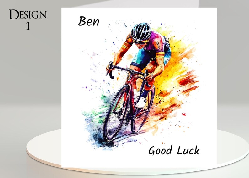 May include: A watercolor-style greeting card featuring a cyclist in action. The card includes the text "Design 1", "Ben", and "Good Luck". The cyclist is wearing a helmet and riding a red bicycle, with colorful paint splashes.