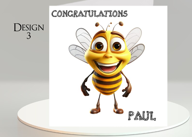 Pu&ograve; includere: Biglietto di auguri con un'ape dei cartoni animati sorridente. La carta ha la scritta "CONGRATULATIONS" in alto e "PAUL" in basso. Il design &egrave; etichettato come "Design 3".