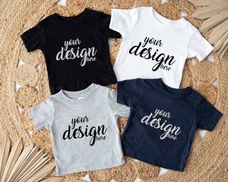 May include: Four short-sleeved t-shirts in black, white, grey, and navy blue. Each shirt has the text "your design here" printed on the front.