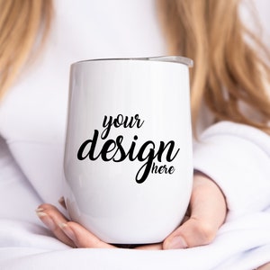 May include: White stainless steel tumbler with a black inscription that reads "your design here".