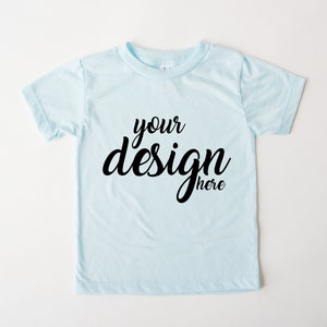 Puede incluir: Una camiseta azul claro con el texto "your design here" en negro.