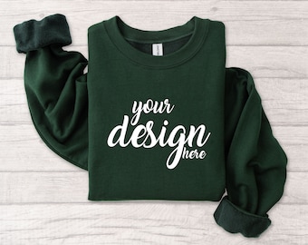 May include: A dark green sweatshirt with the text "your design here" printed in white on the front.