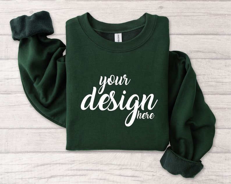 May include: A dark green sweatshirt with the text "your design here" printed in white on the front.