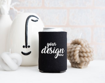 May include: Black neoprene can cooler with white text that says "your design here".