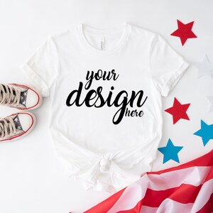 K&ouml;nnte beinhalten: Wei&szlig;es T-Shirt mit dem Text "your design here" auf wei&szlig;em Hintergrund mit roten, wei&szlig;en und blauen Sternen und einer amerikanischen Flagge.