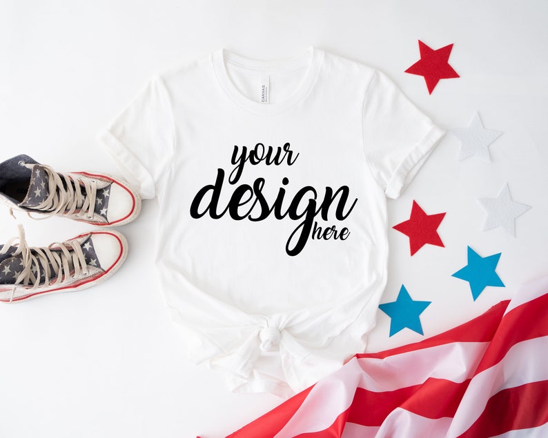 K&ouml;nnte beinhalten: Wei&szlig;es T-Shirt mit dem Text "your design here" auf wei&szlig;em Hintergrund mit roten, wei&szlig;en und blauen Sternen und einer amerikanischen Flagge.