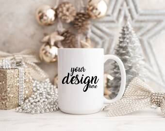 Puede incluir: Taza de cerámica blanca con un diseño negro que dice "your design here". La taza está rodeada de decoraciones navideñas plateadas y doradas.