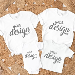 Könnte beinhalten: Vier weiße T-Shirts mit dem Text "your design here" auf jedem. Die Shirts sind in einem Kreis auf einem geflochtenen Strohhintergrund angeordnet.
