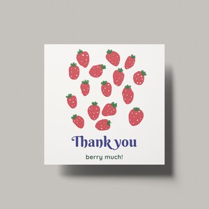 Puede incluir: Una tarjeta blanca con un patrón de fresas rojas y verdes y el texto "Thank you berry much!" en azul.