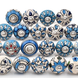 May include: A set of 20 ceramic cabinet knobs with blue and white floral patterns. The knobs are round and have a silver finish.