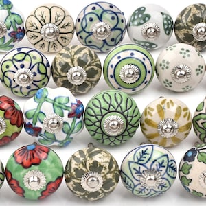 Pode incluir: Uma coleção de vinte puxadores de armário decorativos em cerâmica. Cada puxador apresenta um design floral único pintado à mão em várias cores, incluindo verde, vermelho, azul e branco. Os puxadores têm uma base de metal prateado.