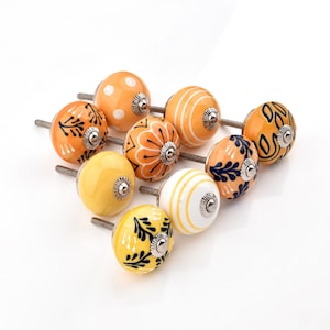 Hand-painted ceramic round knobs in yellow and orange with floral; dresser knobs and cabinet pulls for furniture hardware.