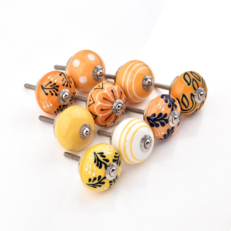 Hand-painted ceramic round knobs in yellow and orange with floral; dresser knobs and cabinet pulls for furniture hardware.