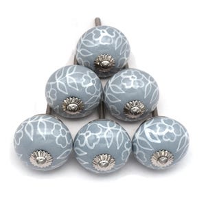 gray ceramic cabinet knobs, hand-painted in white with stripes, dots, flowers, stars, and hearts.