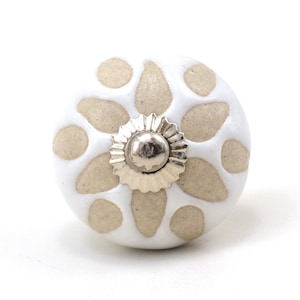 Può includere: Pomo in ceramica bianca con un motivo floreale beige e un centro in metallo argentato.