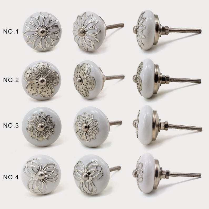 White ceramic cabinet knob with a silver flower motif and gold center; decorative furniture knob for cabinets and drawers.
