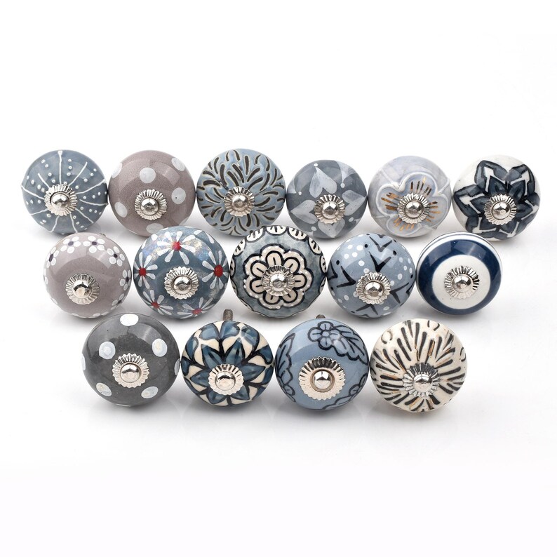 Assorted ceramic cabinet knobs, handpainted in blue, gray, and white with mandala and floral patterns for cabinet hardware.