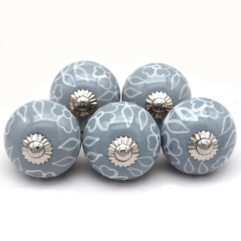 Grey ceramic knob with white hand-painted floral pattern; vintage shabby chic cabinet drawer pull with silver mounting stud.