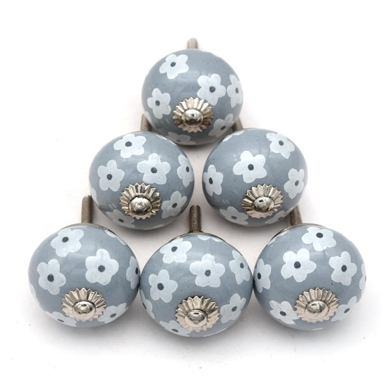 gray ceramic cabinet knobs, hand-painted in white with stripes, dots, flowers, stars, and hearts.