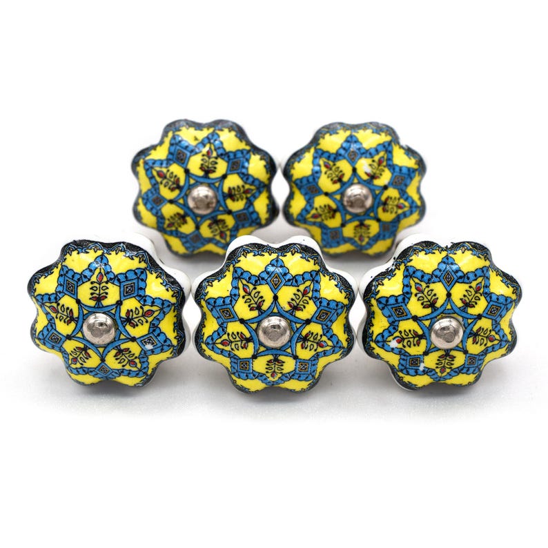 Hand-painted ceramic furniture knob with scalloped edge, yellow and blue mandala pattern, metal screw center for drawer pull.