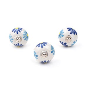 Assorted hand-painted ceramic knobs with blue and turquoise floral motifs for kitchen décor and knob cupboards.